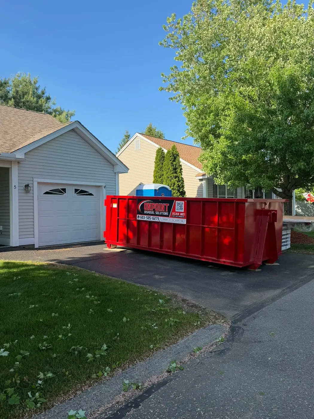 Onpoint Disposal Solutions roll off dumpster in a residential driveway ready for loading